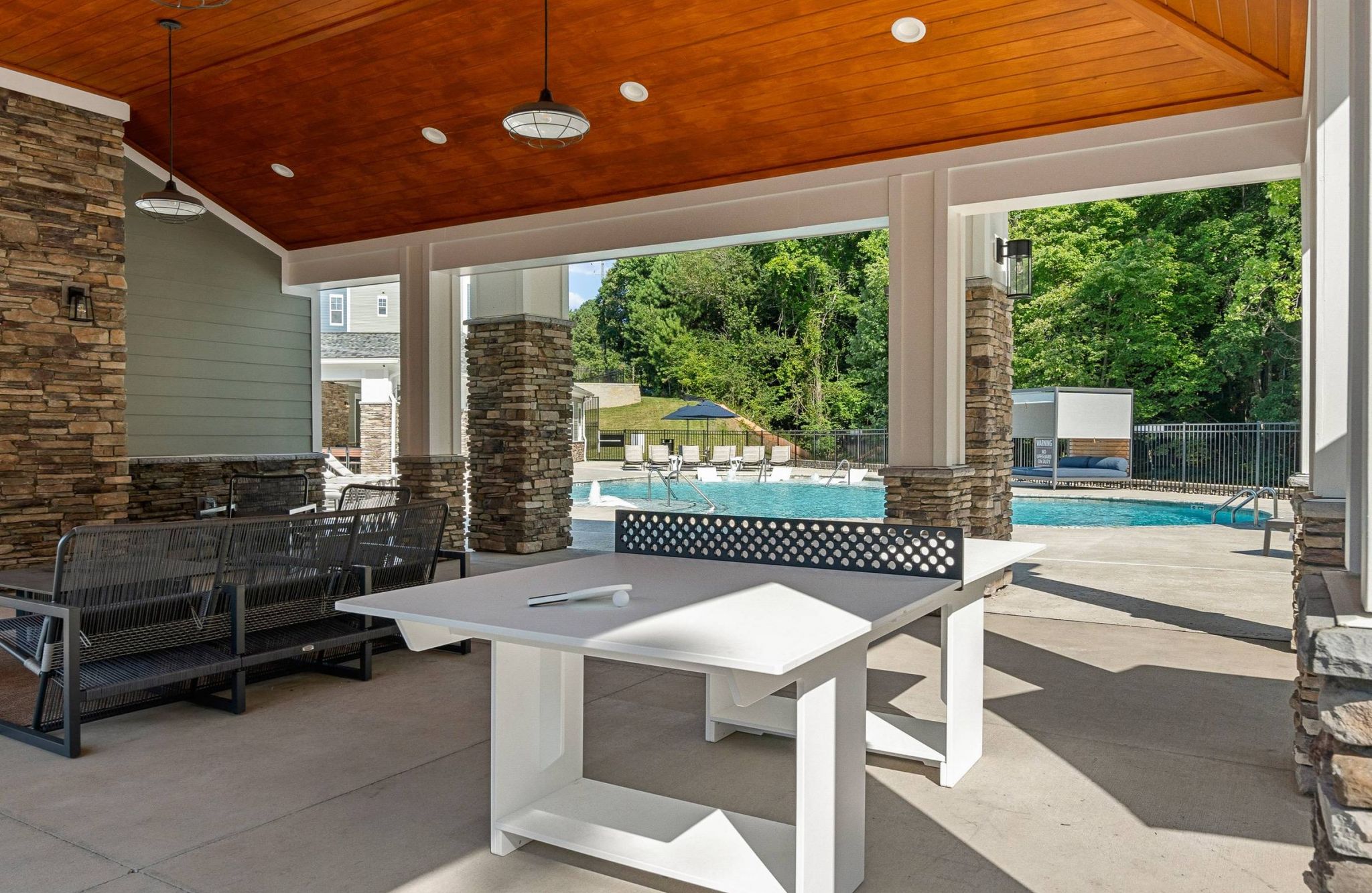 Hawthorne at the Forest outdoor amenity lounge area with ping pong table and entertainment space with pool